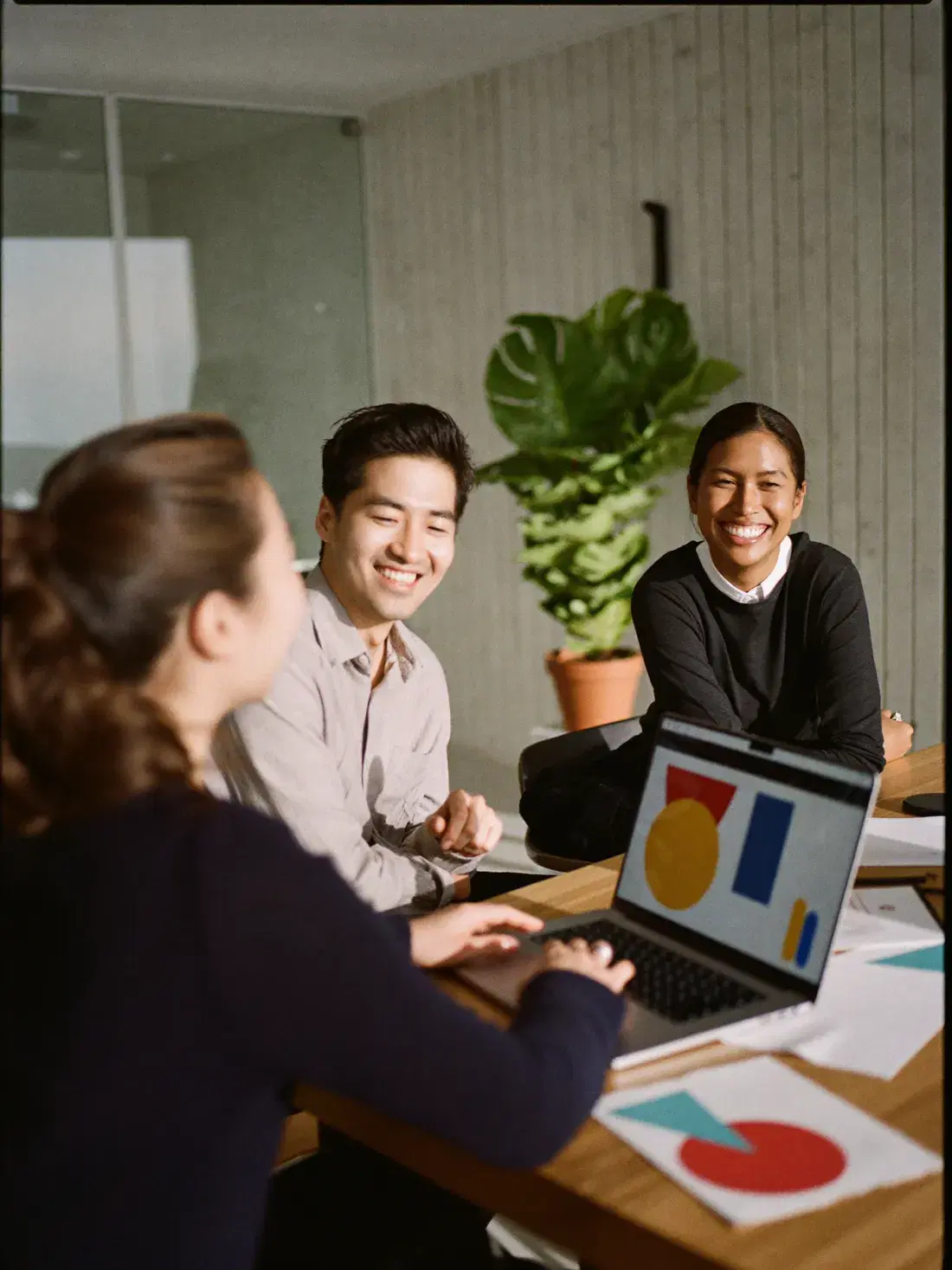 A marketing team laughing while they review campaign results on a laptop